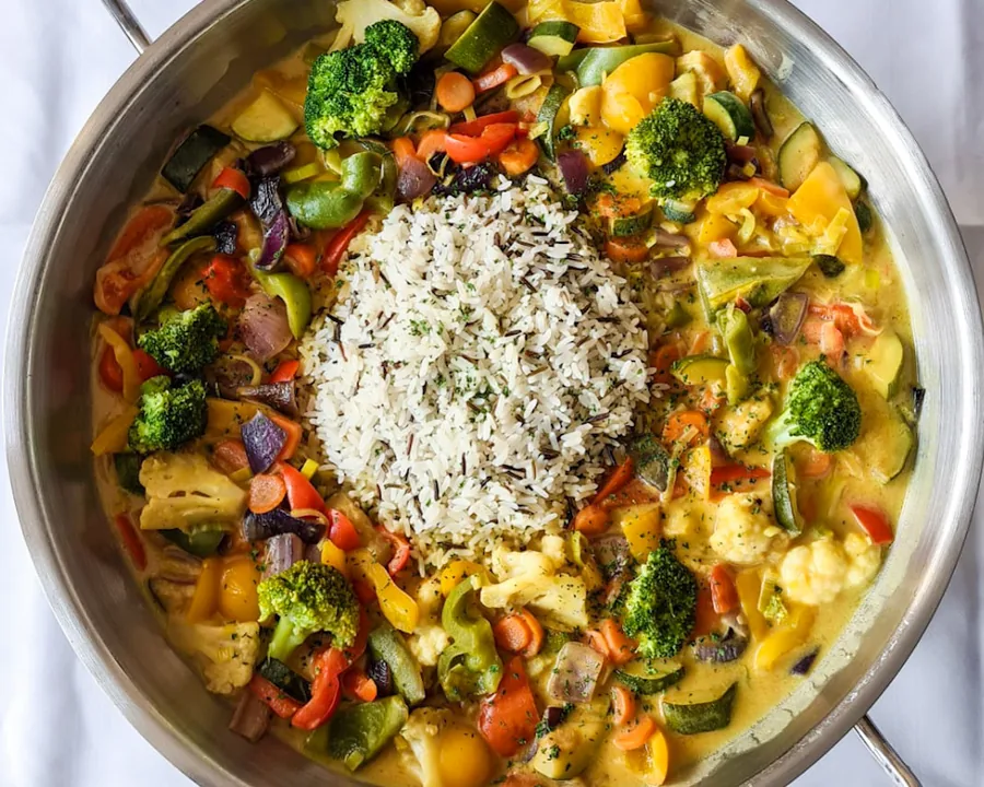 Vegane Gemüsecurrypfanne mit Reis und buntem Gemüse in der Servierpfanne