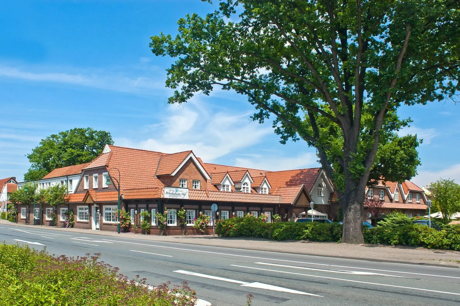 Das Hotel Wardenburger Hof unter alten B&auml;umen an der Oldenburger Stra&szlig;e in Wardenburg